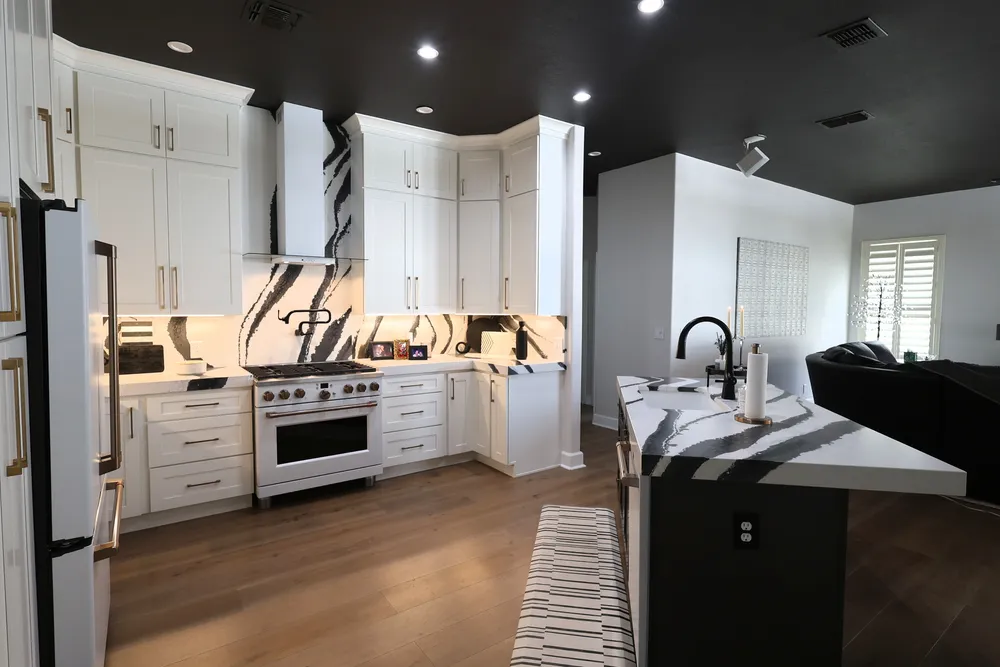 Reverse view of the Blackwater range wall and quartz island with a black sink faucet.