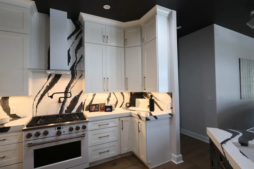 Angled view of the Blackwater range, white cabinets and illuminated quartz backsplash.