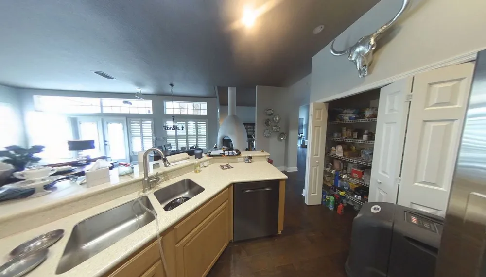 Sink-side view of the original Blackwater peninsula, wood cabinetry and open pantry.