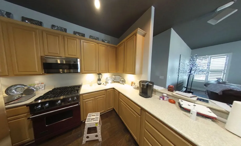 Original Blackwater cooking wall with wood cabinets, a freestanding range and an overhead microwave.