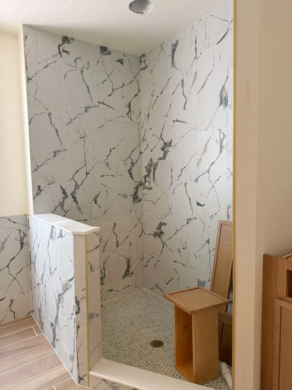 Marble-look shower tile installation detail in the Calle bathroom.