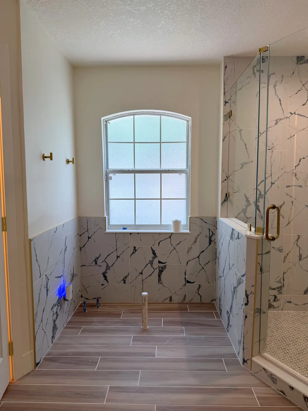 Tiled tub bay with temporary plumbing in the Calle bathroom.