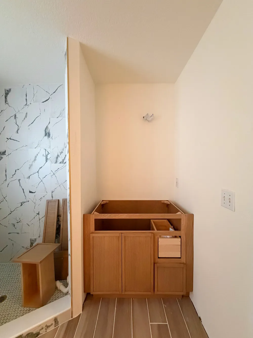 Open vanity cabinet installation in the Calle bathroom.