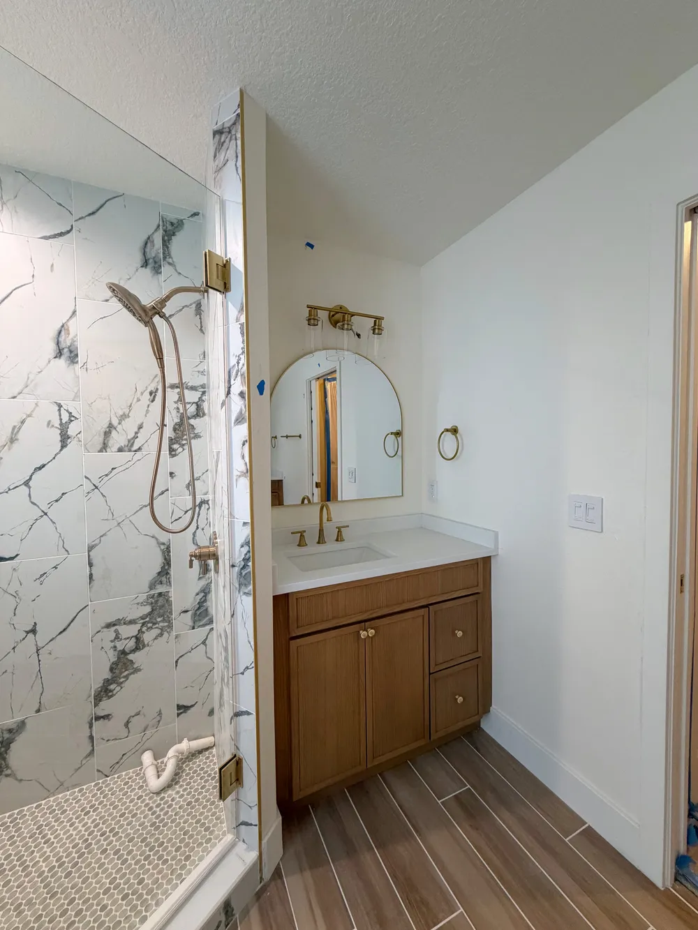 Late-stage shower and vanity view in the Calle bathroom.