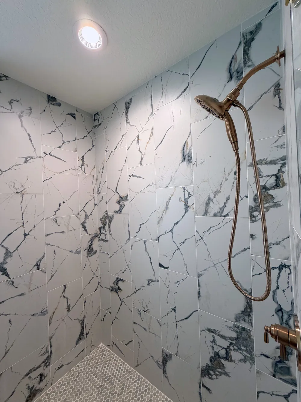 Shower tile and handheld fixture detail in the Calle bathroom.