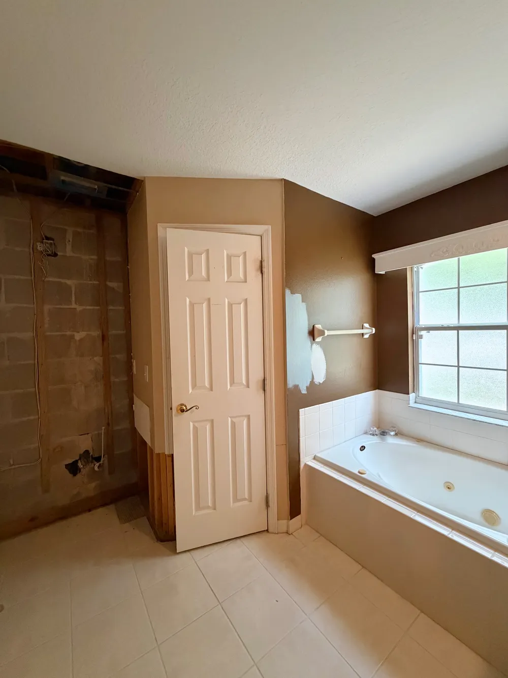 Existing tub beside opened shower in the Calle bathroom.