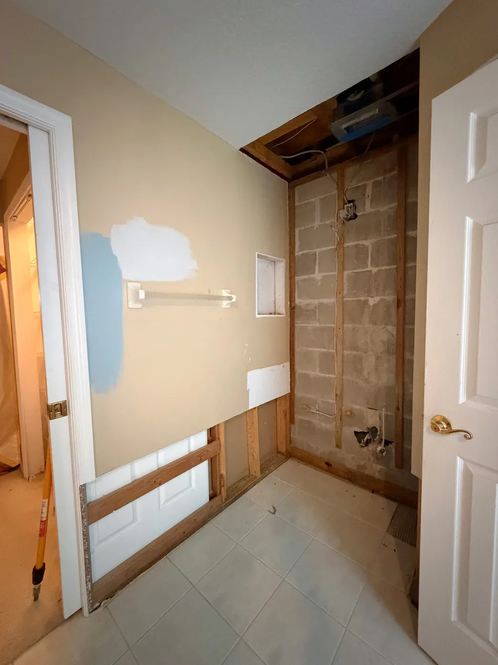 Opened wall and exposed rough-in in the Calle bathroom.