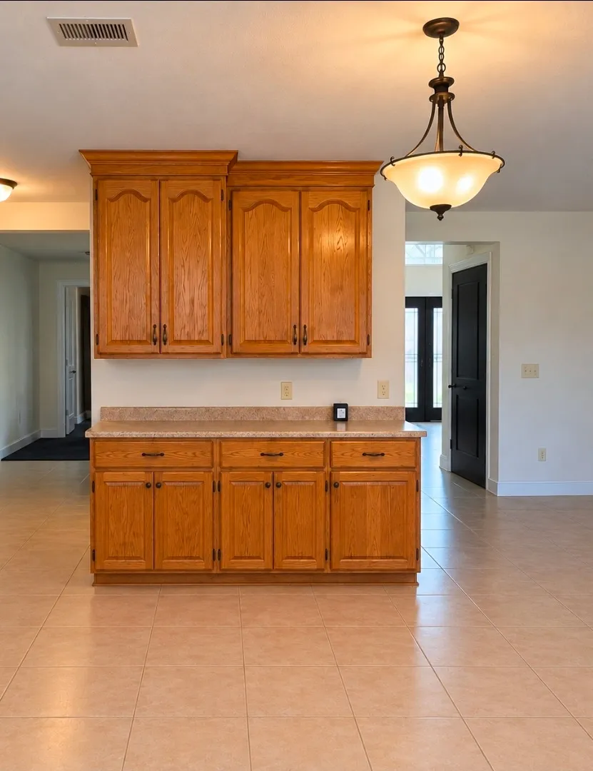 Oak upper and lower cabinets with a decorative ceiling light in the Lake Roper kitchen before renovation.