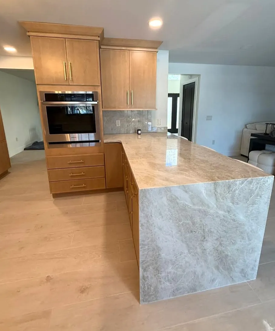Built-in wall oven and warm wood cabinetry beside a quartz waterfall peninsula at Lake Roper.