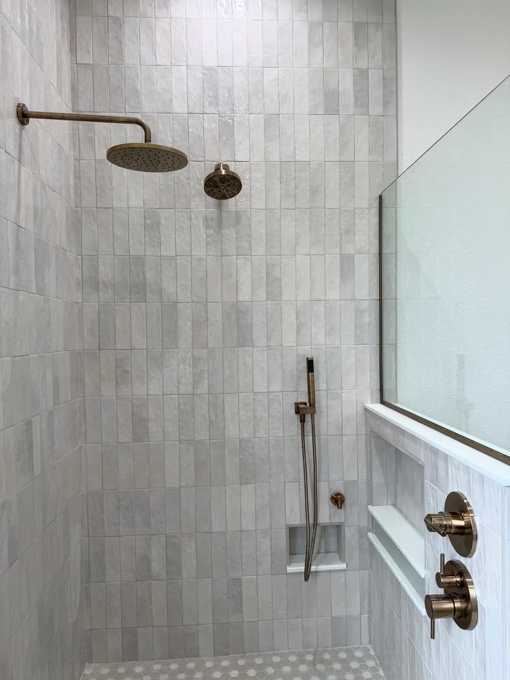 Finished shower fixtures and niche in the Pompano bathroom.