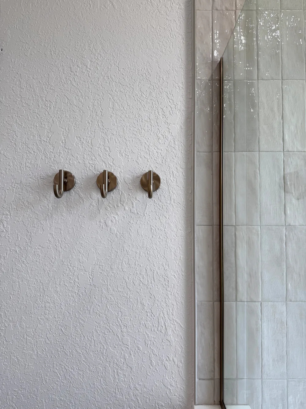 Finished towel hooks and glass edge in the Pompano bathroom.