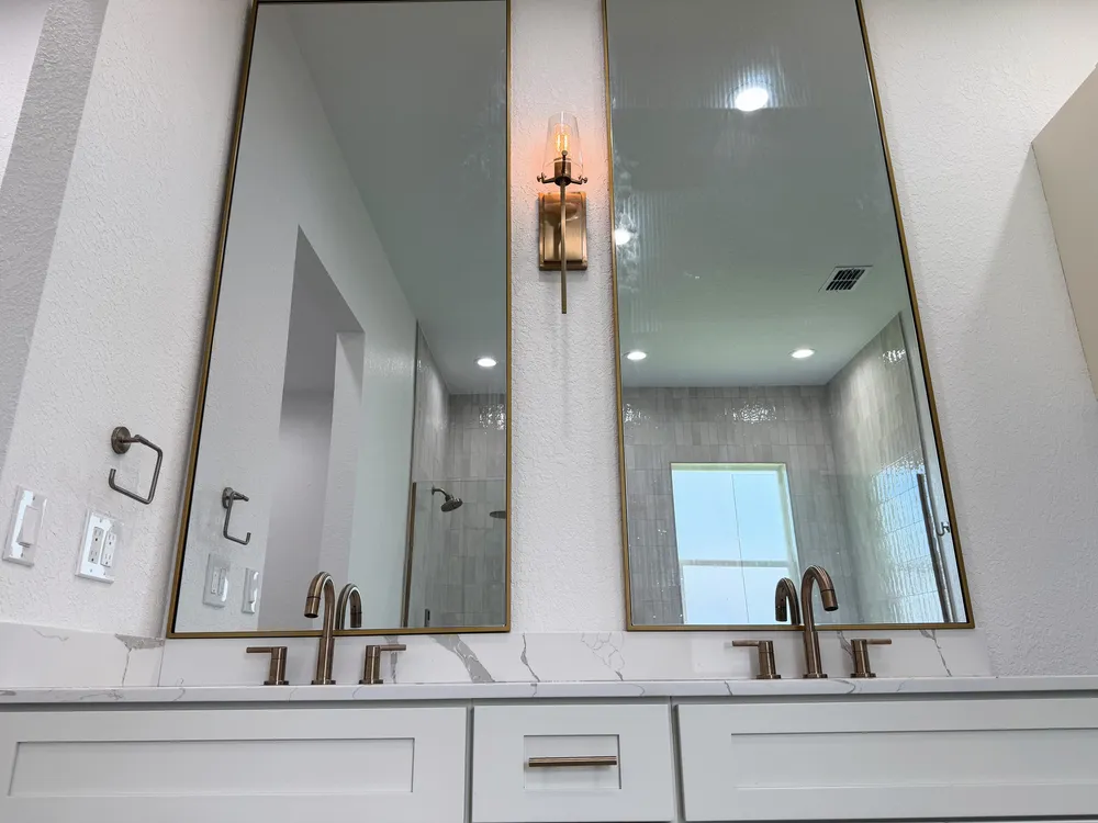 Finished vanity sconce and mirror detail in the Pompano bathroom.