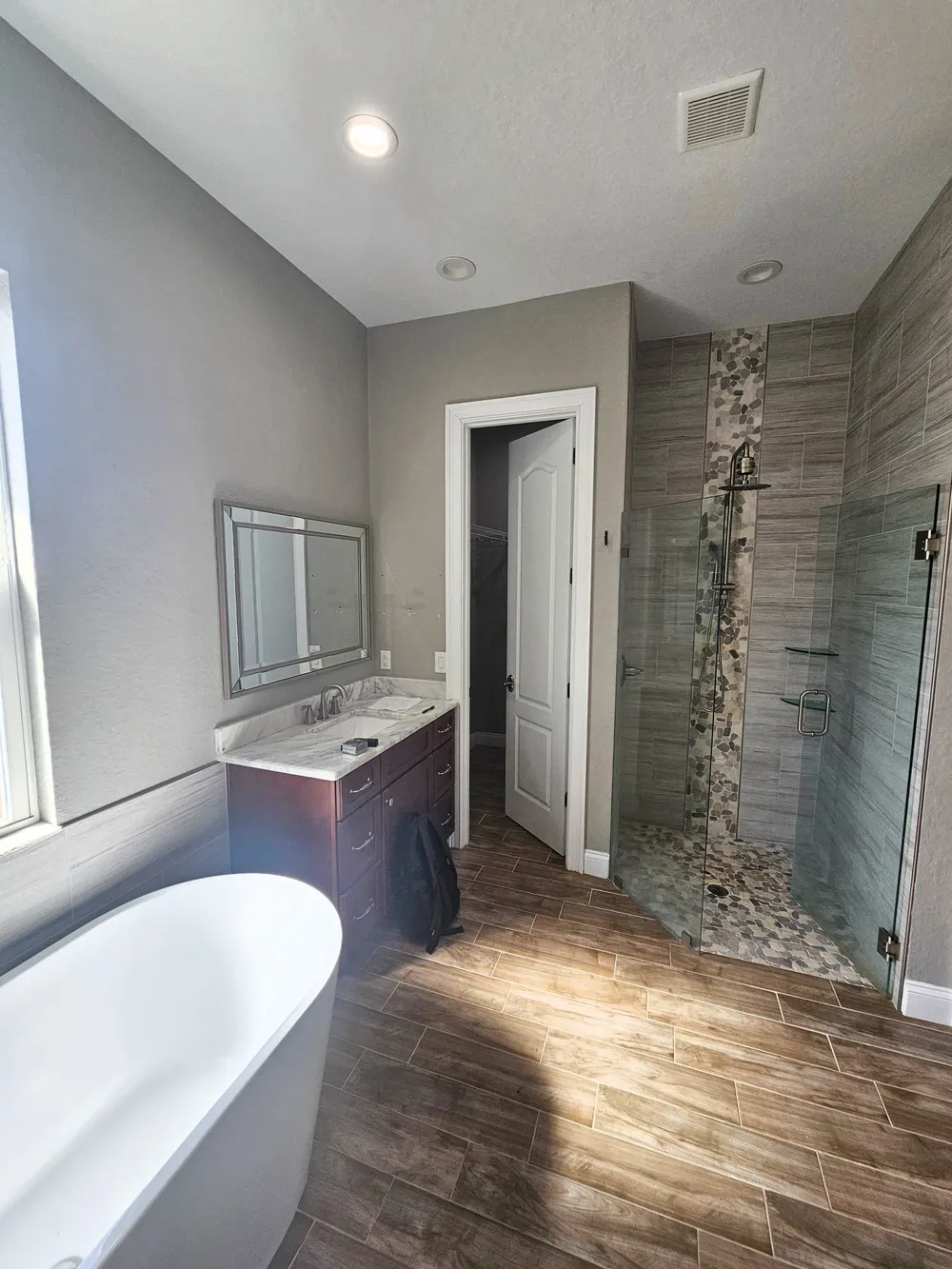 Original Pompano bathroom with a tub on the left, dark wood vanity, and enclosed shower.